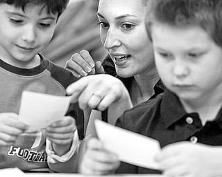 Kate Florig helps Nico Mascarella, 6 of Youngstown, and Zack Eckert, 8 also of Youngstown, come up with ways to imitate the animals they have drawn during a game of animal charades at the Children's Center for Science and Technology on March 25, 2009. Florig, who studies child psychology at Kent State volunteered her time at the center where her mother, Suzanne Barbati, was recently named the new executive director.