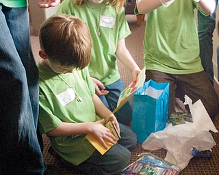 During the spaghetti dinner at St. Charles Church in Boardman Ed Driscoll retreats from the rush to a back room to open a birthday present following a chorus of the birthday song from his sister Claire (age 9...but double check), brother, Dan, 10 and other family and friends. The present from a family friend included pokémon toys and candy.