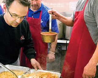 Carmine Cassese, (left) inspects the pasta as and Joe Chahine waits to add more sauce and Jon Saadey, center, looks on in the kitchen at St. Charles Church in Boardman on Saturday afternoon during a fundraiser for Rom Driscolll.
