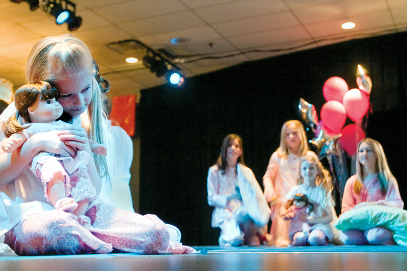 Hannah holds her bitty baby twin close while modeling sleepwear on stage during the American Doll fashion show at Mr. Anthony's Banquet Center on South Avenue in Boardman.
