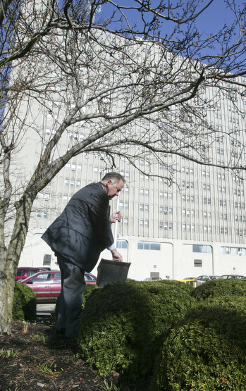 Scott Burin, owner of the International Towers building in downtown Youngstown, Oh. goes through his daily ritual of picking up litter from his property.