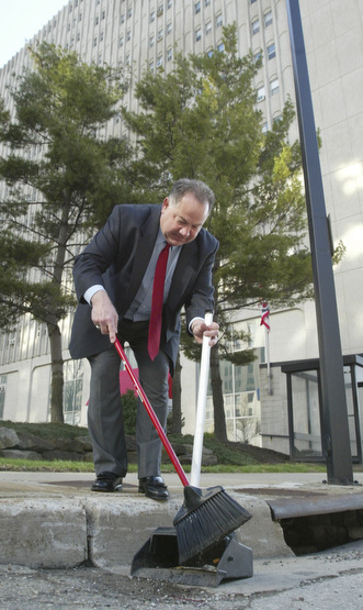 Scott Burin, owner of the International Towers building in downtown Youngstown, Oh. goes through his daily ritual of picking up litter from his property.