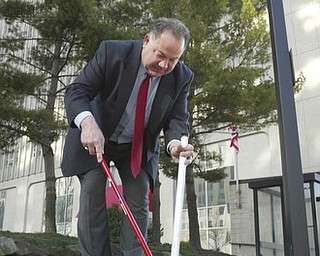 Scott Burin, owner of the International Towers building in downtown Youngstown, Oh. goes through his daily ritual of picking up litter from his property.