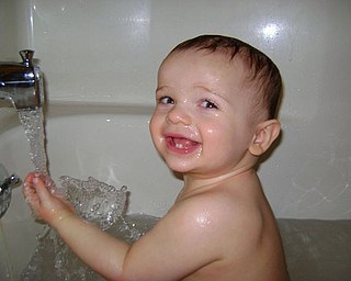 EVAN HRUSKA of Boardman is taking a bath after his first haircut.