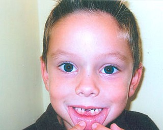ETHAN CLARK, son of Kevin and Kimberly Clark of Columbiana, appears to be telling the photographer “Look, Mom, I lost my first tooth!”
