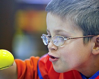 Bo Snyder takes an up close look at perfection as he dips his yellow egg in for more coloring as Preschoolers decorate Easter Eggs at New Life Christian Preschool, 2250 E. Western Reserve Road Poland