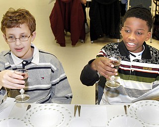 Korey Burdman, 13, of Howland and Maalik Smith, 11, a student at Akiva Academy participate in a Seder at the Jewish Community Center Tuesday.The Seder was dedicated to child nutrition and hunger awareness.