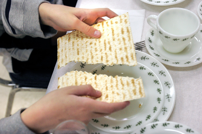 Breaking of Matzah. It is broken to remind people of the brokeness in the world and to recall those who are poor.  Rabbi Frank Muller ofCongregation Rodef Shalom lead a Seder at the Jewish Community Center Tuesday.The Seder was dedicated to child nutrition and hunger awareness. 