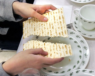 Breaking of Matzah. It is broken to remind people of the brokeness in the world and to recall those who are poor. Rabbi Frank Muller ofCongregation Rodef Shalom lead a Seder at the Jewish Community Center Tuesday.The Seder was dedicated to child nutrition and hunger awareness.