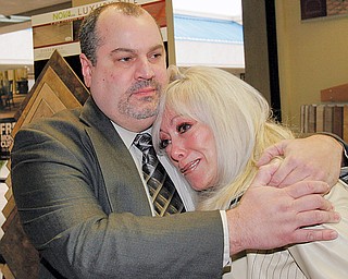 Carpet King general Mgr John Plesea hugs Cindy Barb, widow of Carpet King owner Ron Barb who died in March. She was emotional entering the store.
