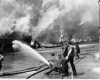 Apr. 26, 1984 Firefighters try to thold the line and keep the flames from moving to the carousel (seen at far right).