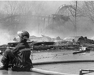 Apr. 26, 1984 A youngstown City Fireman siits on a hose as part of the Wild Cat roller coaster goes up in flames. The 90 year old Idora park went up in flames, destroying the Lost river, park offices and and a row of concessions stands. The two -allarm fire sent one fire fighter to the hospital.