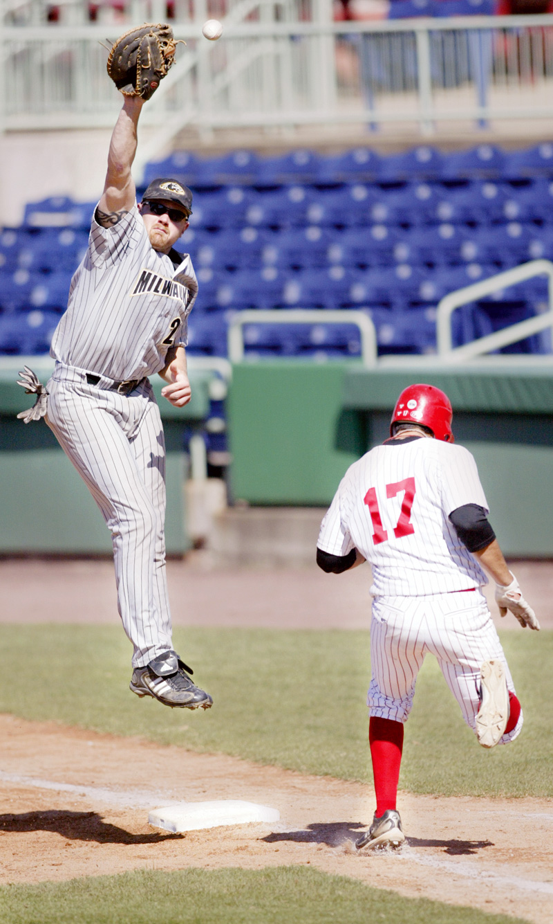 YSU's Jeremy Banks heads to first as Milwaukee 1 rst baseman Dan Buchloz tries to make the catch during 4 th inning at Eastwood Field. Banks was called safe. 