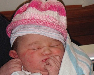 MICHAELA ROBERTS of Bowie Md., granddaughter of Tom and Joanne Roberts of Canfield,
is only 12 hours old here. She’s trying on a hat from Nasa Vennell over her hospital hat, both
of which are too big for her.