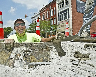 Dave Main, an employee of Cook Paving and Construction. peers out of a manhole on Federal St. in downtown Youngstown Thursday 6/26/08. He and a crew of workers were raising manholes as part of a ongoing downtown paving and sidewalk project. William D. Lewis