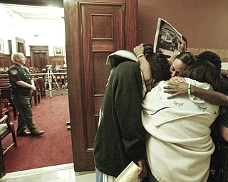 Retia Crawford, facing camera and other members of her family embrace outside a Mahoning County courtroom after Michael Davis found guilty of setting a fire that killed 6 members of the Crawford family. The Vindicator/William D. Lewis