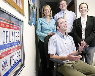 HAPPY TEAM: Doug Carr, Cboss general manager, sits with his management team at the company offices in Boardman. Cboss has been renewed to handle Oplates.com, the state’s online license-plate renewal system. With him are Jennifer Samuel, marketing director, left, Aaron Lego, business development director, and Jenny Hammond, director of operations.