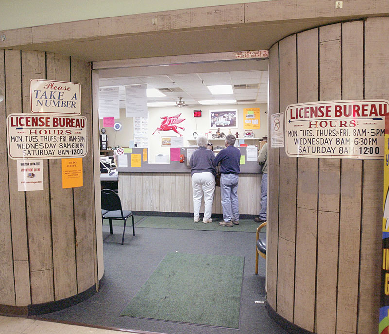 USING THE OFFICE: Two people take advantage of services offered at the Bureau of Motor Vehicles office in Hubbard. The office has been given one year to increase the number of patrons using the facility, or the state will no longer renew its contract.