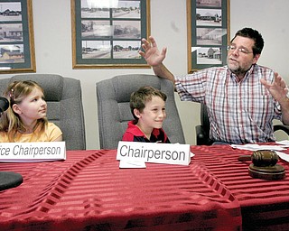 TEMPORARY TRUSTEES: Larry Wehr, a Beaver township trustee, explains the workings of township government to South Range third-graders Megan Kiselica and Cameron Tarr during a mock trustees’ meeting. The educational event took place Friday in the township administrative office.