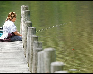 FISH FEEDER:
Debbie D'Altorio of Boardman tries her hand at fishing off a pier in Lake Newport in Mill Creek Park. Although she enjoyed the setting and the milder weather, she said she wasn't having much luck, just feeding the fish with a hook.
