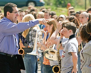 Boardman director of bands Thomas Ruggieri moves the band members into position as they will stand in position to "script out 100."