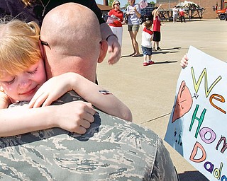 8-year-old Tayla Jones of New Waterford hugs her father John with his son Jonathan, 6, on the right holding a sign.
