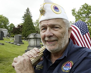 JP Brown III, former national Amvets Cmdr. helps decorate graves in Youngstown's Oak Hill Cemetery.