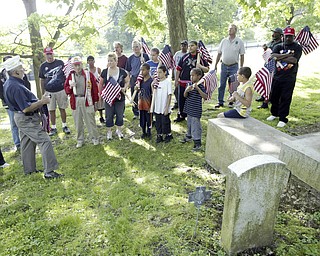 JP Brown III, left of Boardman, a  Navy veteran and former Amvets National Commander leads a brief ceremony at the grave of Maj. John A. Logan in Oak Hill Cemetery Sat May 16. Veternas groups and volunteers placed flags on graves at the cemetery.