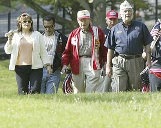 JP Brown III, right of Boardman, a Navy veteran and former Amvets National Commander leads a group of veterans and volunteers as they place flags on graves of veterans in Oak Hill Cemetery in Youngstown, Oh. From left others are Karen Brandt, Ed Romero and Raymond Braidich.