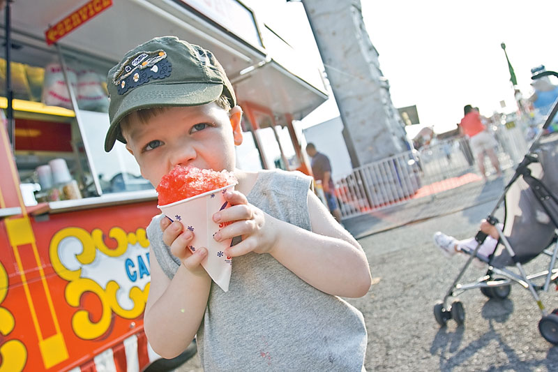 3-year-old Landon Joyce of Boardman bites into a cherry sno-cone at the Southern Park Mall Event of Bates Brothers Carnival, Friday May 22, 2009.