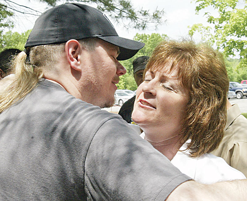 UAW members Molly Less of Berlin center and James Simlins of Boardman embrace outside Metroplex after vote Thursday.