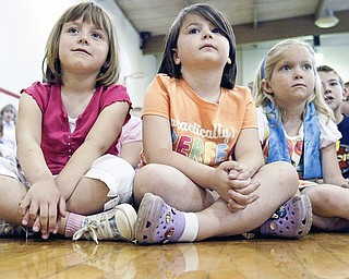 C.H. Campbell Elementary School kindergarten students, from left to right, Eliza Blasko, Emma Conroy and Lily Grdic watch during an Arbor Day program at their school Thursday in Canfield.