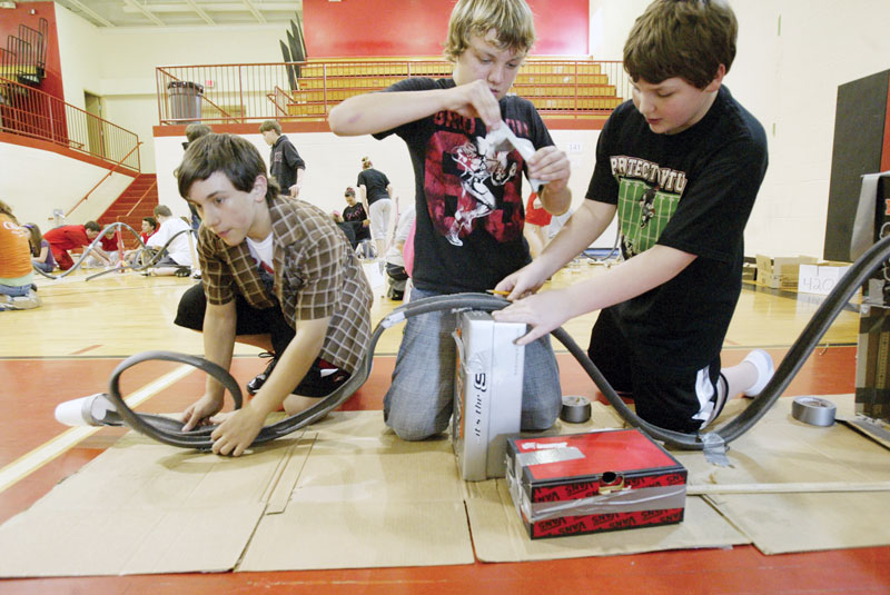 From left to right, Matthew Deal Dustin Thailing and Jesse New work on their coaster during roller coaster contest at Girard Junior High School. 7th graders participated in the event Friday.