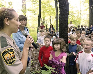 ODNR Division of Wildlife Officer Jamey Graham, left, speaks during a dedication of Wild School Site at Poland Union Eelm. School Tuesday. Next to her is Poland Union 2nd grade teacher Linda Watts. Students gathered outside the school for the dedication.
