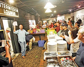 Ken Bassinger starts to auction off sets of dinnerware at the Youngstown Playhouse.