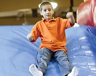First grader Nicholas Boyarko of C.H. Campbell in Canfield runs through bounce course at the school Friday as part of end of year festivities.