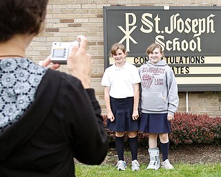 Nicole Strollo takes a photograph of her daughter Rachel, 11, and friend Maddie Sanders, 12, outside St. Joseph School for the last day, June 5 2009