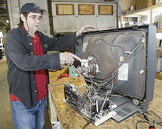 Val-e-Tronics owner Gary Piskor, prepares to disassemble an old analog TV set at his Mahoning Ave site in Youngstown. They disassemble and recycle TV's and computers.