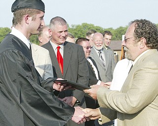 Springfield grad Drew Duraney gets his diploma from Springfield Board of Education member Len Fagnano during Sunday commencement.