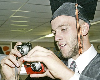 Two fisted photographer and 2009 Springfield HS grad Todd Kibby snaps photos of fellow grads during Sunday commencement.