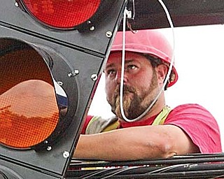 Bink Harter, an employee of Perram electric of Wadsworth, installs new traffic signal at Liberty and Hall avenues in Hubbard on June 8. New signals are being installed in the city.