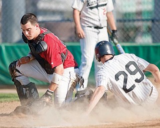 Austintown Fitch's Jason Bagoly (22) catches behind home plate against North Ranger Baseball team at Cene Field as North Ranger Chris Thompson (29) comes in on May 21.