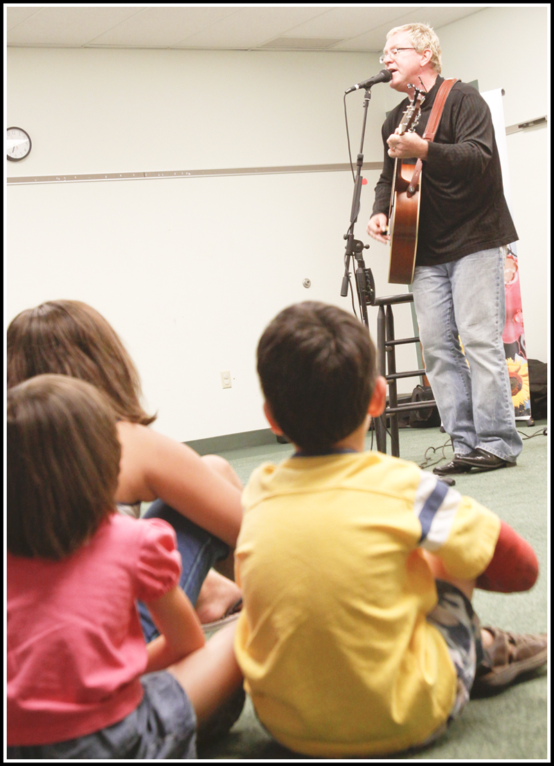 Abby Schindell (5) and her brother Joshua (6) of Hubbard sing along with other children and adults with Chip Richter as he performs in the Media Room at Hubbard Local Library on Monday June 15, 2009.
Photo by: Lisa-Ann Ishihara