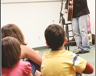 Abby Schindell (5) and her brother Joshua (6) of Hubbard sing along with other children and adults with Chip Richter as he performs in the Media Room at Hubbard Local Library on Monday June 15, 2009.
Photo by: Lisa-Ann Ishihara