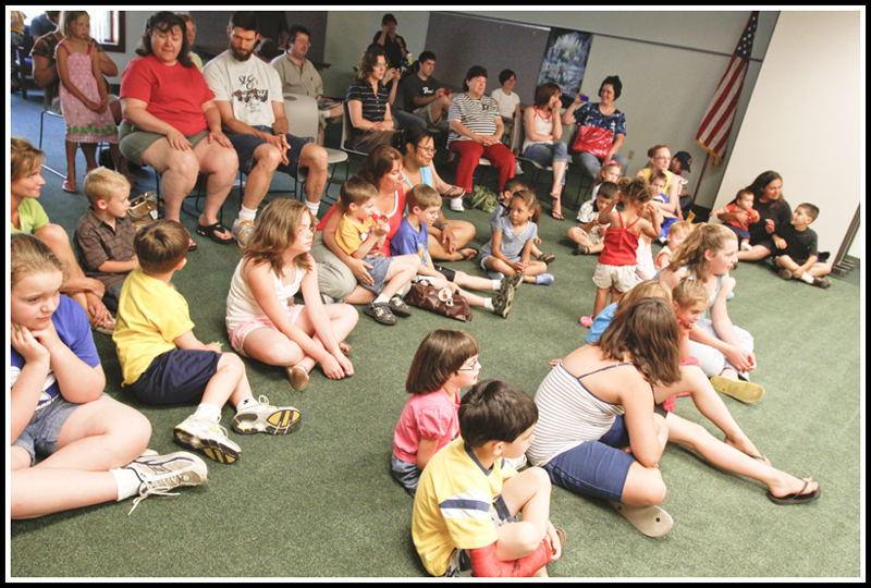 Children and adults sing along with Chip Richter as he performs in the Media Room at Hubbard Local Library Monday June 15, 2009
Photo by: Lisa-Ann Ishihara