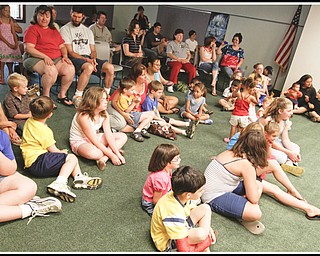 Children and adults sing along with Chip Richter as he performs in the Media Room at Hubbard Local Library Monday June 15, 2009
Photo by: Lisa-Ann Ishihara