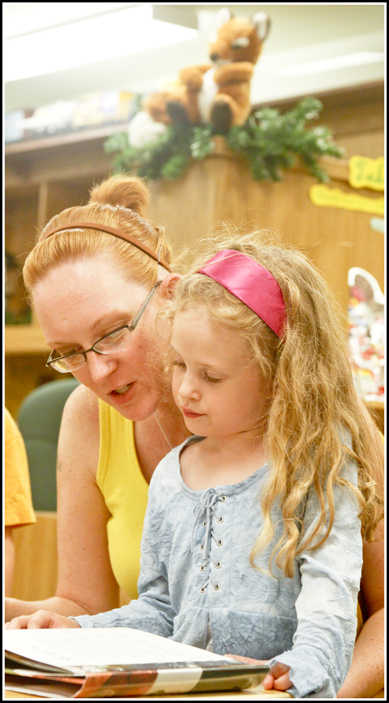 Camp Read: Rachel Scacchetti of Hubbard reads to her daughter Isabella (5) to pass time in the Hubbard Children's Library before they watch Chip Richter perform in the Media Room, Monday June 15, 2009
Photo by: Lisa-Ann Ishihara