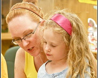 Camp Read: Rachel Scacchetti of Hubbard reads to her daughter Isabella (5) to pass time in the Hubbard Children's Library before they watch Chip Richter perform in the Media Room, Monday June 15, 2009
Photo by: Lisa-Ann Ishihara