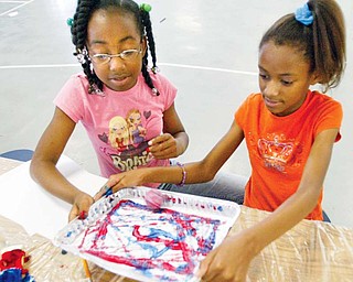 Eagle Hgts studnets Jalyssa Stanford, 10, left, and Rayonna Booth, 10 roll pingpong ball in a pan of paint during Camp Invention program at the school 6-18-09. wdlewis