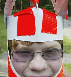Matt Stark, 13, a member of Boy Scout Troop 46 of Boardman dons a knight's helmet while helping out at Cub Scout Day camp Thursday at Camp Stambaugh in Canfield. The theme of the camp was "knights of the round table." wd lewis
